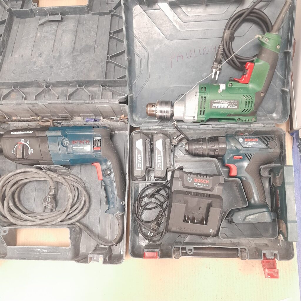 Maletas abertas com ferramentas elétricas e baterias para mobilização de obra