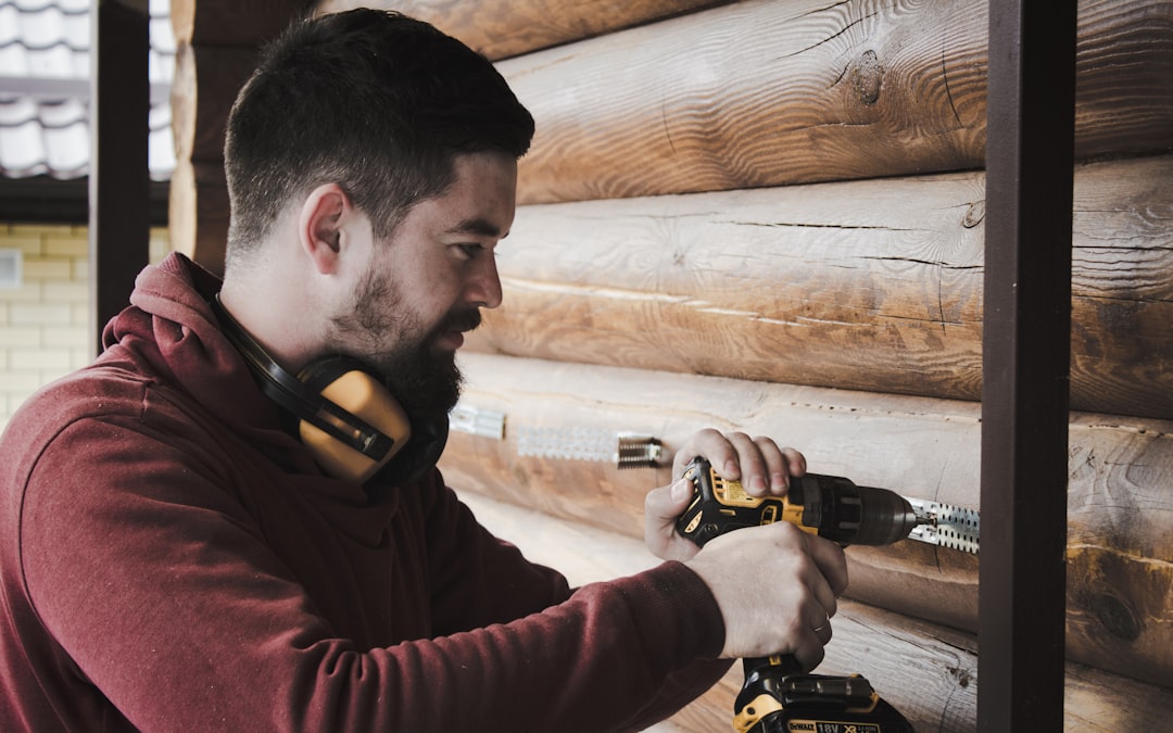 Profissional usando uma ferramenta elétrica para perfurar uma parede durante uma obra